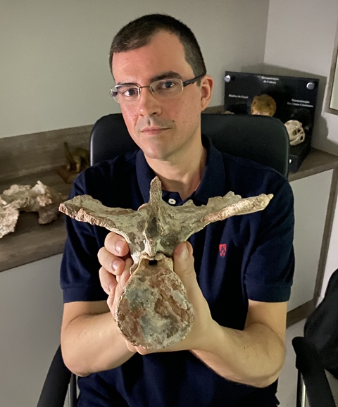 Fabiano Iori segura fóssil da vértebra caudal do Kurupi itaata